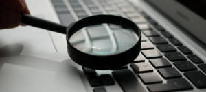 Une loupe au-dessus d'un clavier d'ordinateur
