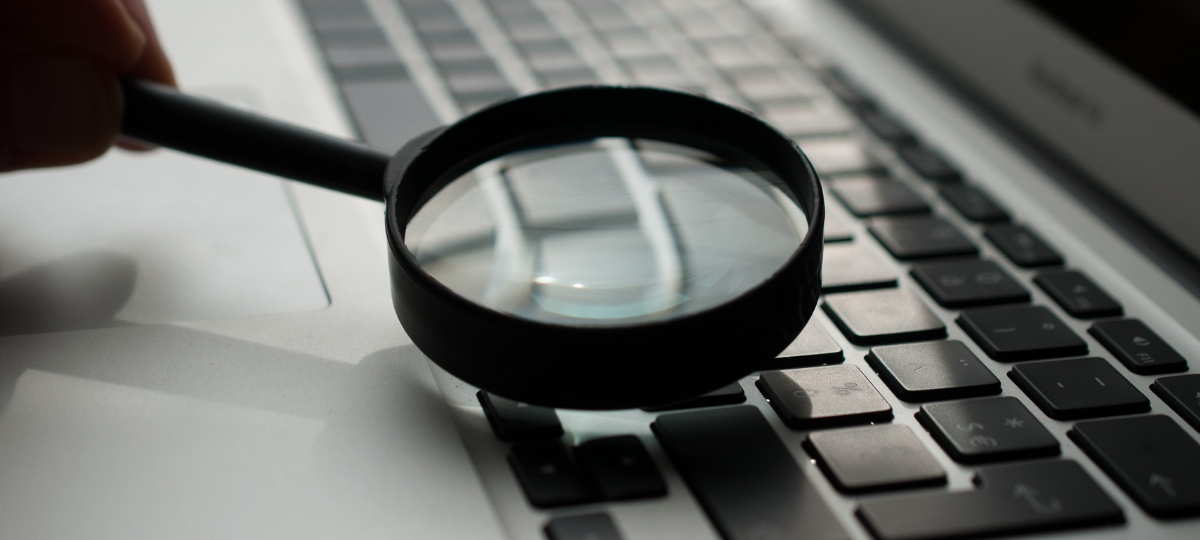 Facebook veut faire preuve de transparence Une loupe au-dessus d'un clavier d'ordinateur