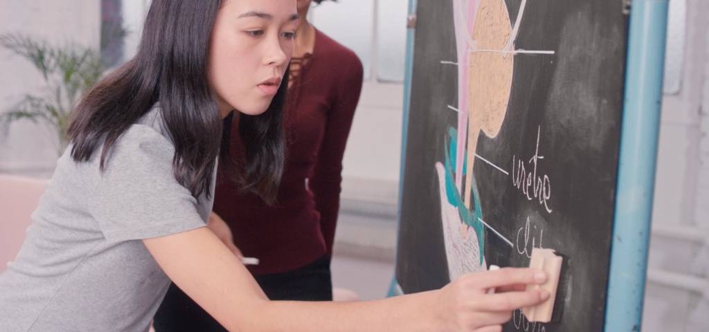 Une fille qui écrit sur un tableau