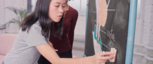 Une fille qui écrit sur un tableau