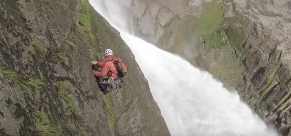 Un homme qui escalade une cascade