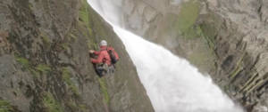Un homme qui escalade une cascade