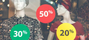 Une vitrine avec deux mannequins et des promotions