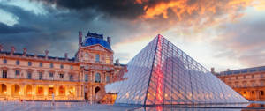 La pyramide du Louvre au coucher du soleil, traversée par un éclair rouge