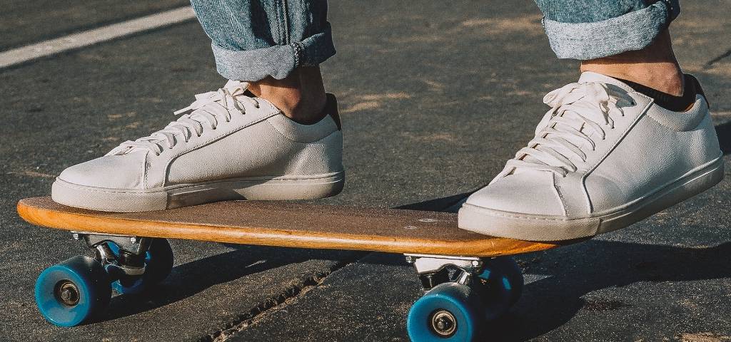 Des baskets blanches sur un skateboard