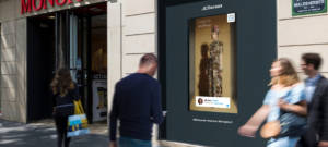 Un homme devant une vitrine Monoprix