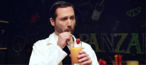 Un homme qui boit un jus avec une paille