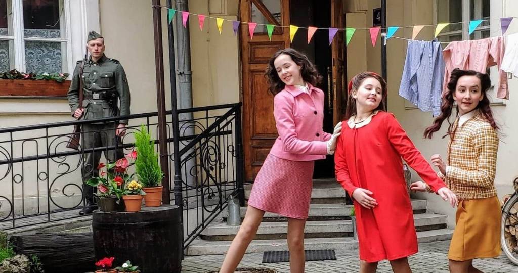 3 trois jeunes filles dansent devant un soldat de l'Holocauste