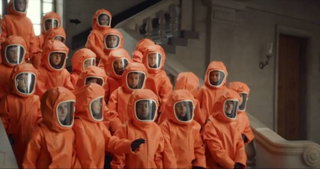 Un groupe d'enfant font une photo de groupe en combinaison dans un musée