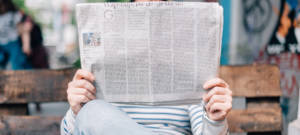 Homme sur un banc lisant un journal