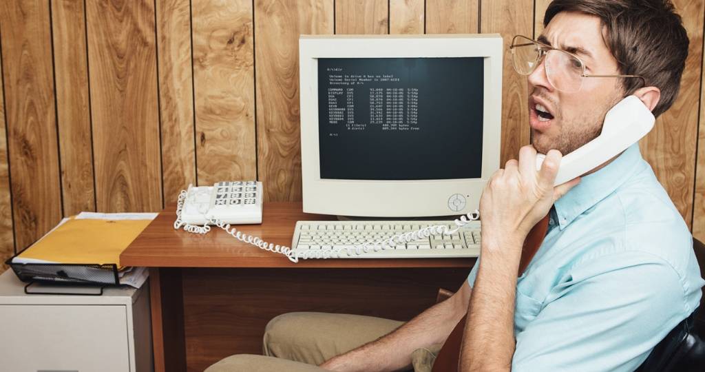 Un homme au travail devant un vieil ordinateur