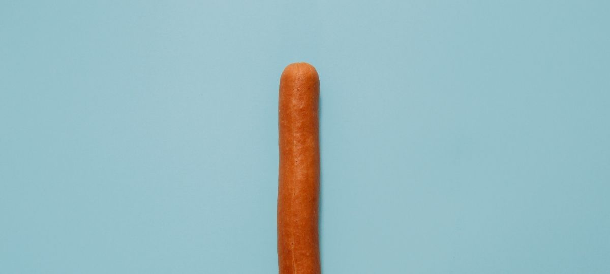 Une saucisse sur fond bleu pastell