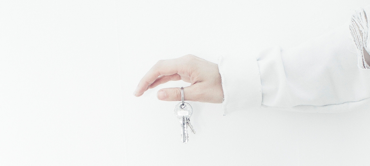 airbnb Une mùain sur fond blanc tient une clés