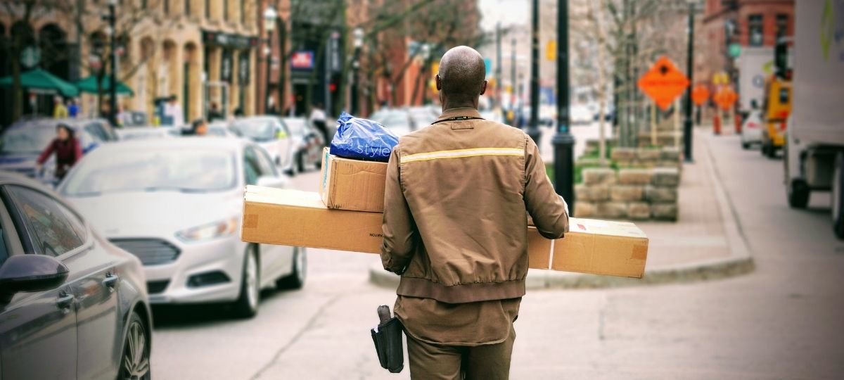 Amazon paie se employés pour qu’ils démissionnent et deviennent livreurs Un homme, de dos, porte des colis.