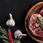 Deux morceaux de viande de boeuf placé sur une planche, sur une table en ardoise