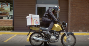 Un livreur Burger King monte sur sa moto