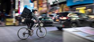Un livreur en vélo, traverse un centre-ville