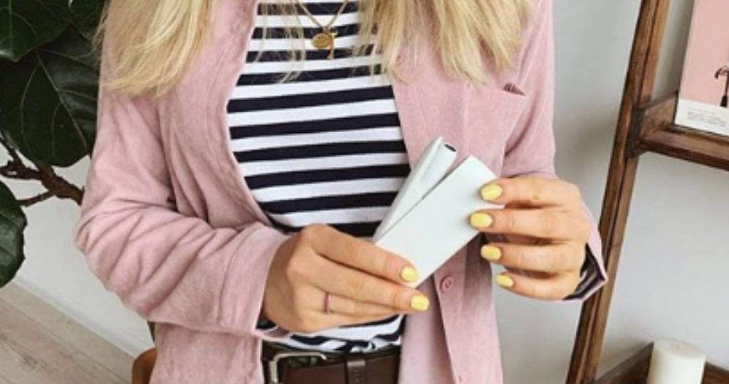 Une jeune femme tient une cigarette électronique IQOS