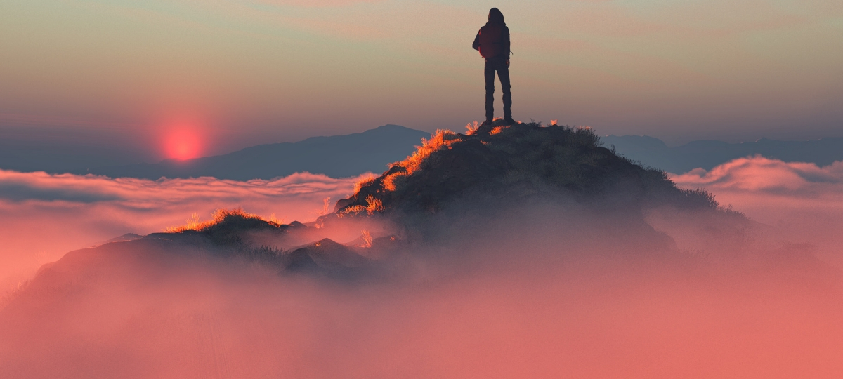 Comment être en tête des résultats sur Amazon ? Un homme au sommet d'une montagne au dessus des nuages roses