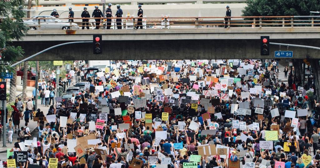 Une foule de manifestants traverse le dessous d'un pont.
