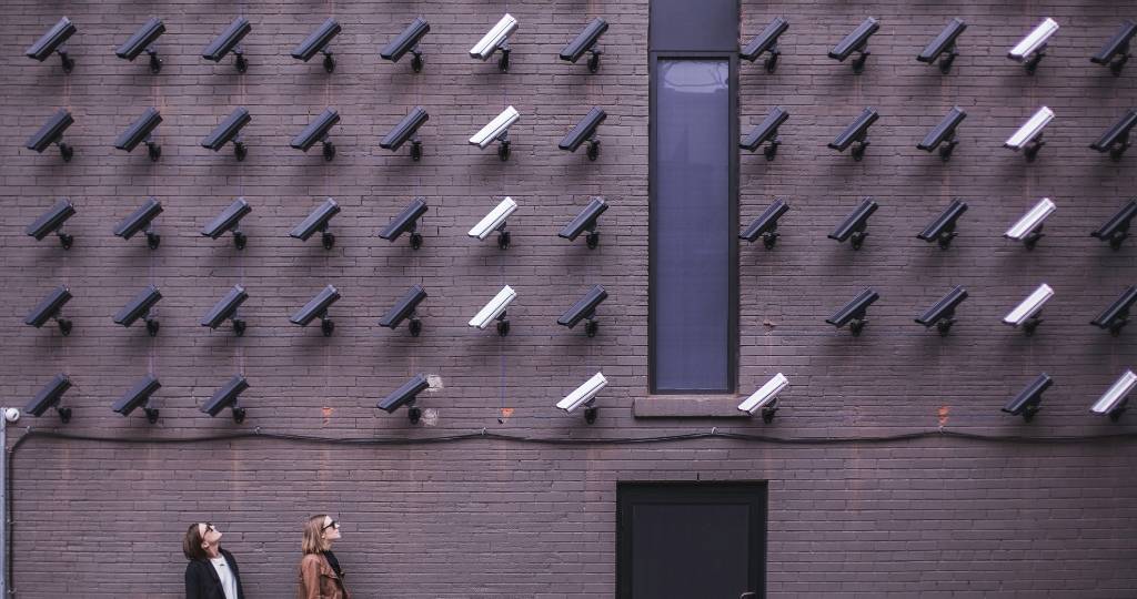 deux femmes regardent un mur de caméra de surveillance