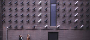 deux femmes regardent un mur de caméra de surveillance
