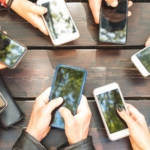 Des mains avec des smartphones autour d'une table