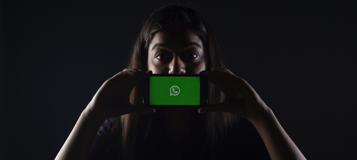 WhatsApp connait une faille de sécurité par un logiciel espion israélien Une femme tient son smartphone devant sa bouche. Sur l'écran, la plateforme WhatsApp