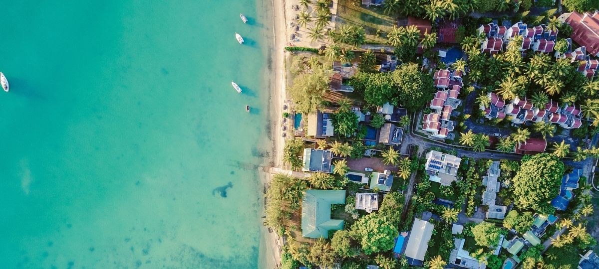 Airbnb entre sur le marché du tourisme de luxe et lance Airbnb Luxe Vue du ciel d'une île tropical. Des villas et des bateaux sur une eau translucide