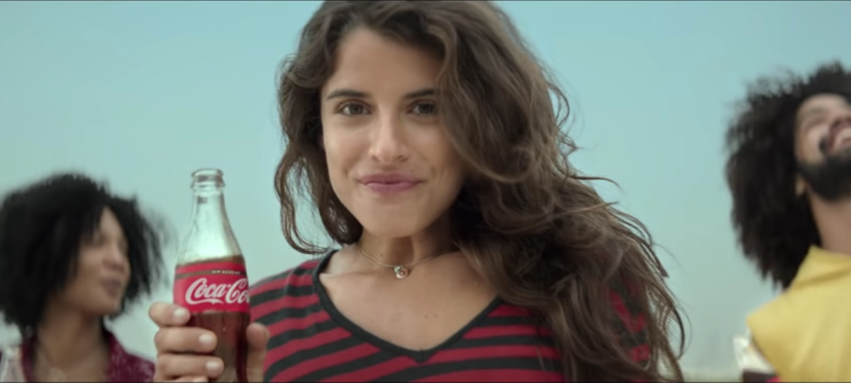 Le Top 10 des pubs les plus vues sur YouTube Une femme avec une bouteille de Coca-Cola dans la main