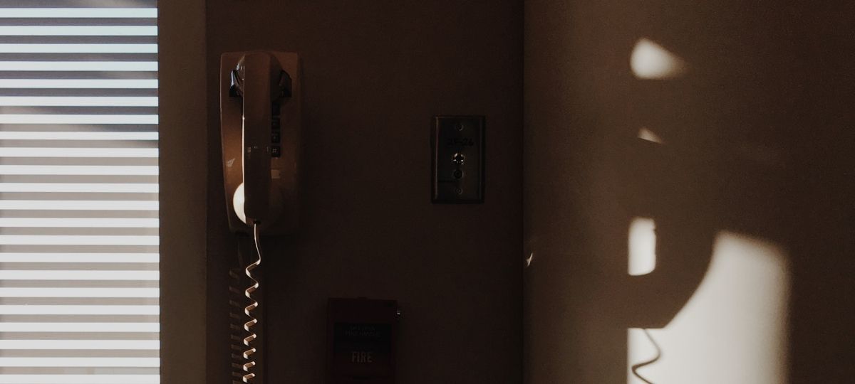 COM-ENT : une ligne d’écoute contre le harcèlement en communication Un téléphone mural dans un salon à la lumière du matin