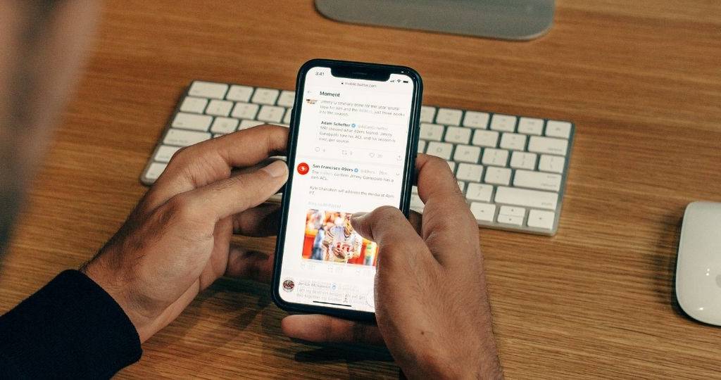 Une homme regarde une page du réseau social Twitter sur son téléphone
