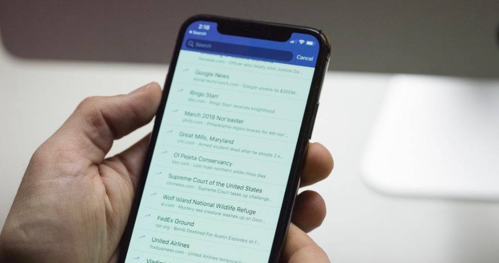 Une main qui tient un smartphone sur la plateforme social Facebook