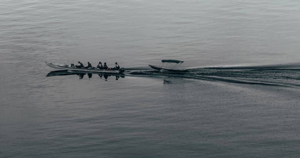 Journaliste sur l'environnement, un métier à risque ?  Un long bateau longe un lac exotique