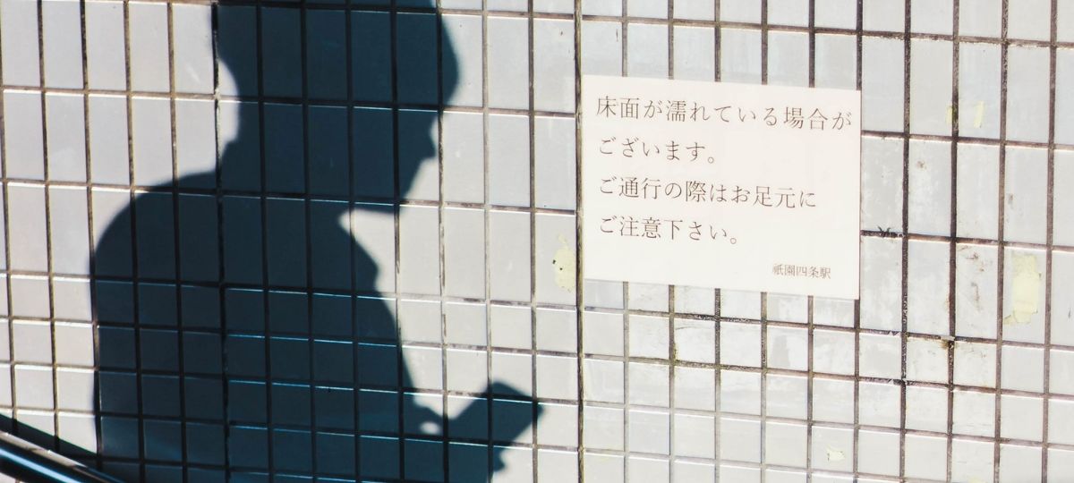 Line instaure le crédit social sur sa plateforme au Japon Ombre d'un homme tenant son téléphone, sur le coté une affiche japonaise