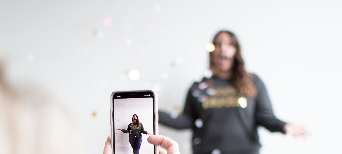 La publicité va (sûrement) débarquer sur TikTok Une jeune femme se fait filmer par son ami, devant un mut blanc