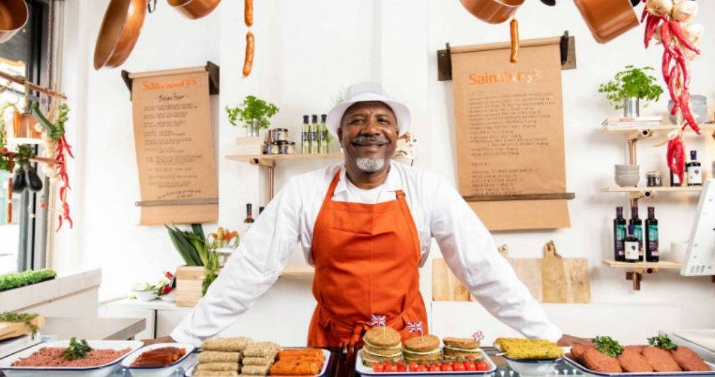 Un boucher Sainsbury's se tient devant son étalage de viande à base végétale