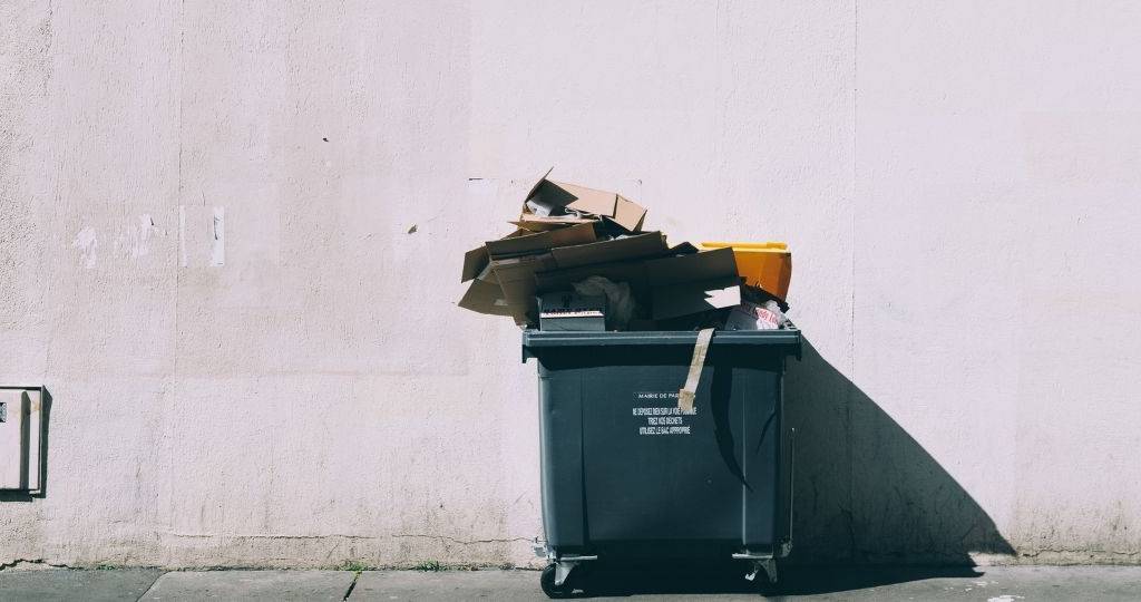 Le gouvernement oblige les fast-food a (vraiment)trier leurs déchets Une benne à ordure noir, contre un mur clair
