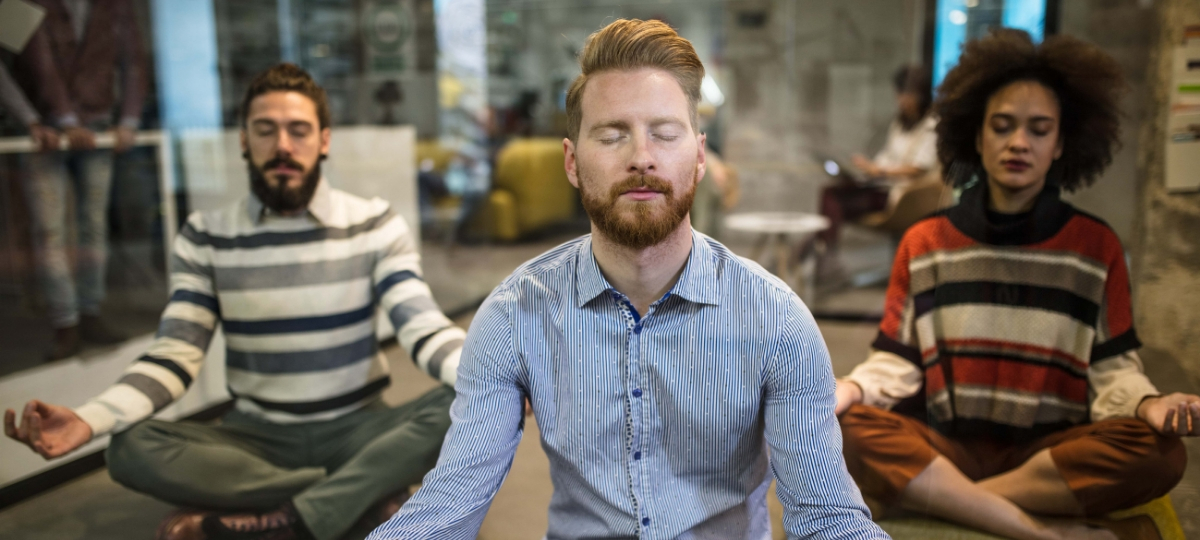 Comment améliorer son expérience collaborateur ? Trois personnes qui font du yoga au burea