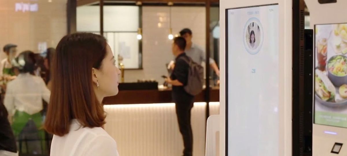 Alipay ajoute des filtres sur ses interfaces de paiement Une femme devant un borne de paiement AliPay