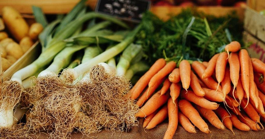 Un étalage de légumes, composé de carotte et de poireaux