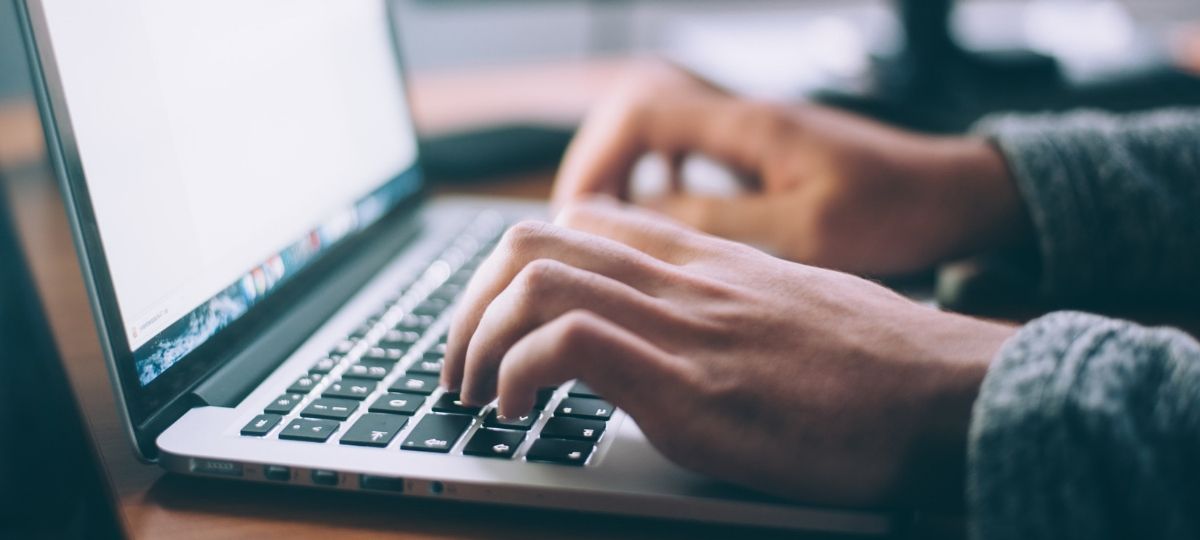 L’ADN Groupe recrute un community manager Une homme rédige sur un ordinateur portable