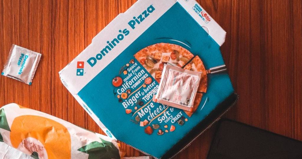 une boite pizza Domino's sur une table en bois
