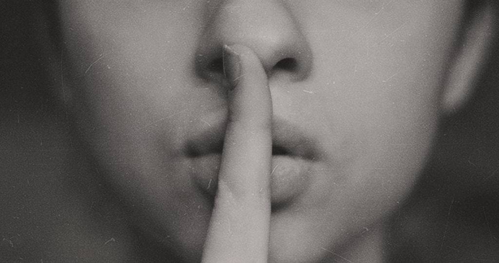 Une femme avec un doigt sur la bouche