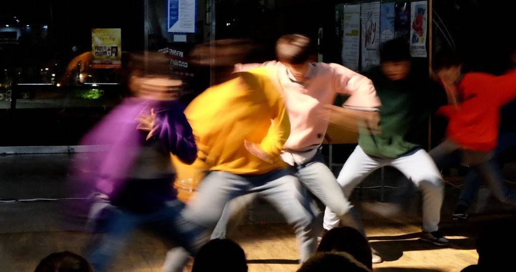 Un groupe d'hommes danse dans une rue coréenne