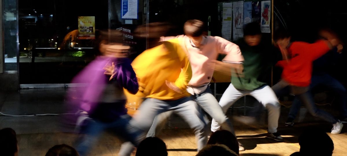 Deezer met en avant les genres musicaux asiatiques avec Asian Music Un groupe d'hommes danse dans une rue coréenne