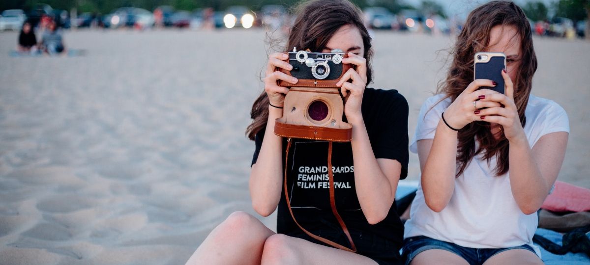 Les adolescent fuient Facebook pour le plus grand bonheur d'Instagram Deux jeunes adolescentes prennent des photos à la plage sur leur téléphone et un appareille photo