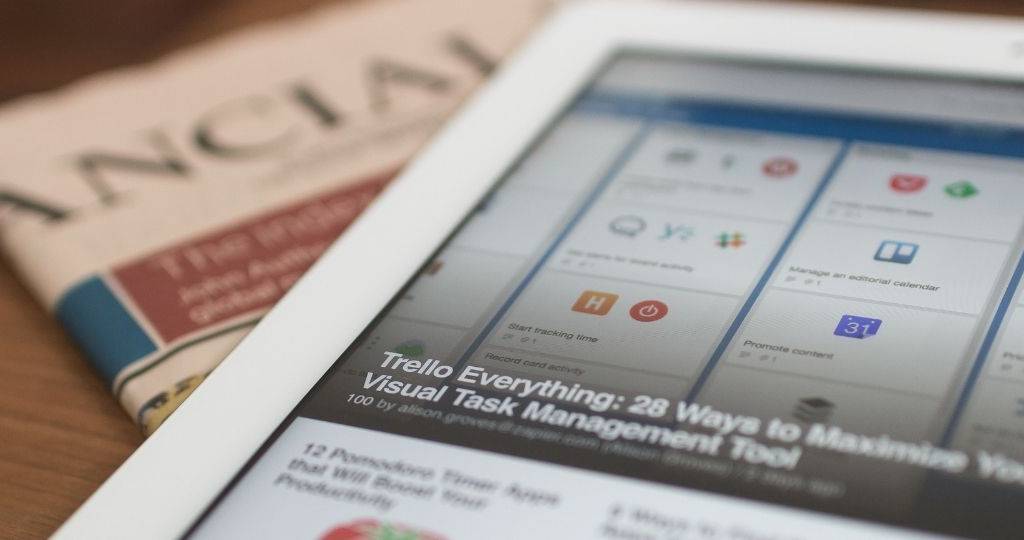 Une tablette tactile posée sur un journal
