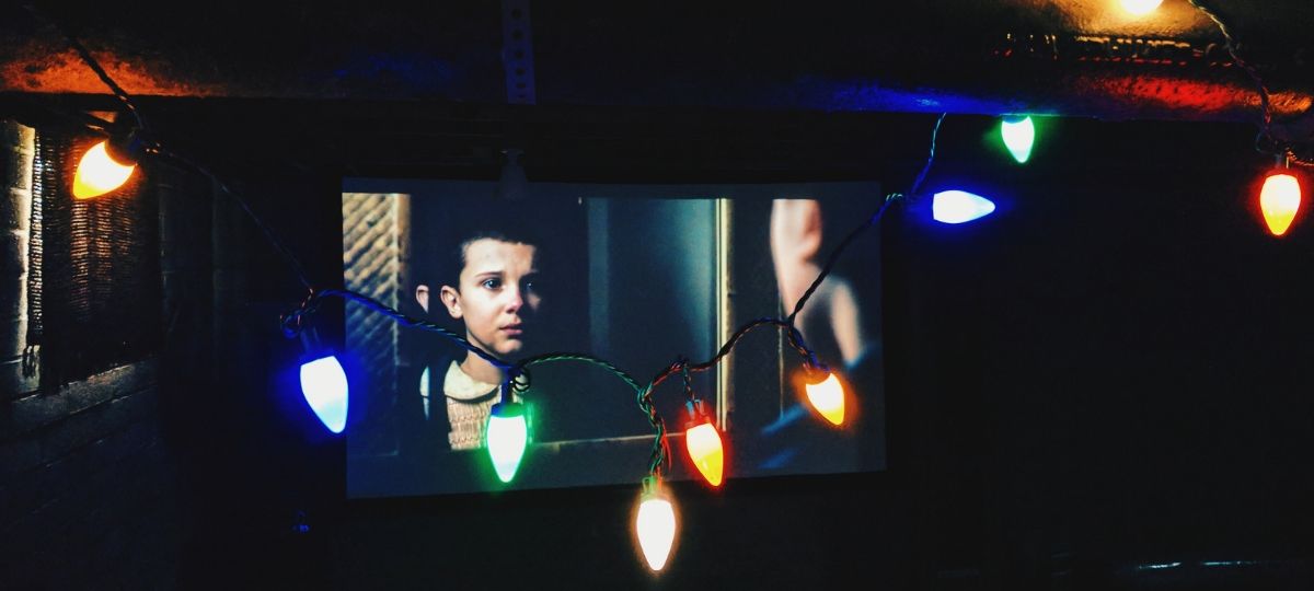 Netflix va réduire son budget de production contenus originaux Télévision dans un salon, diffusant la série Netflix, Stranger Things