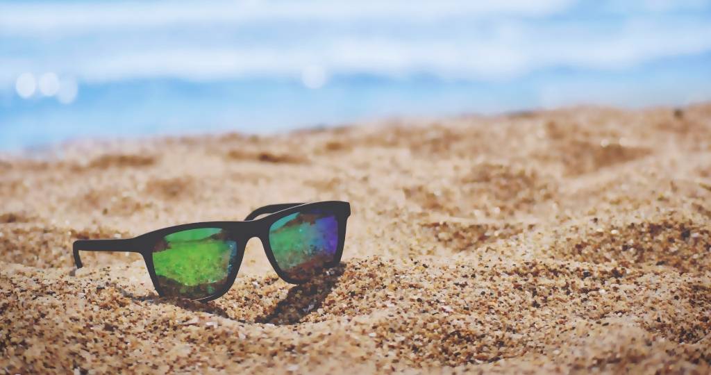 Une paire de lunette de soleil sur le sable